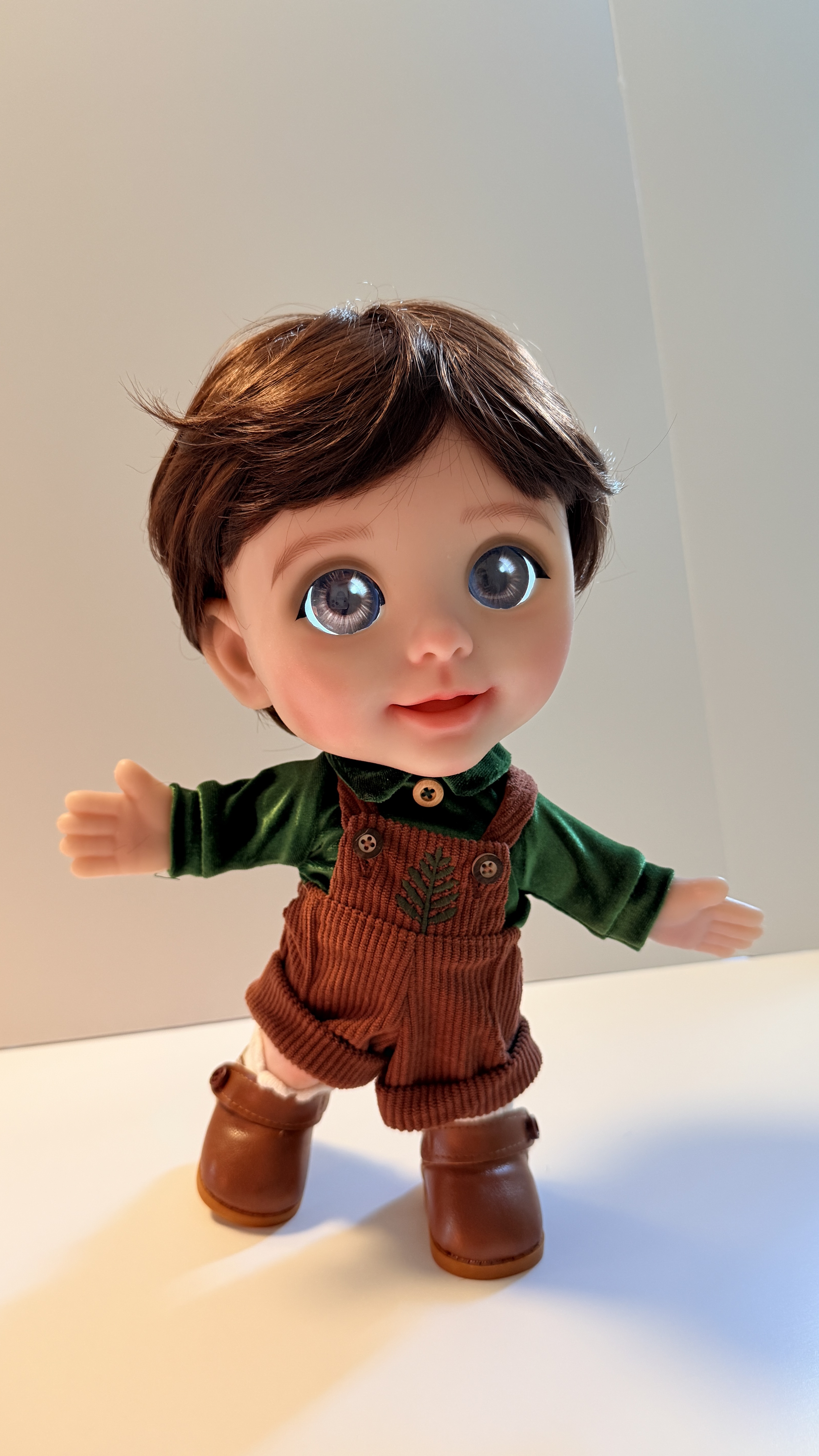 Joy with short brown hair in the green velvet shirt and corduroy overalls