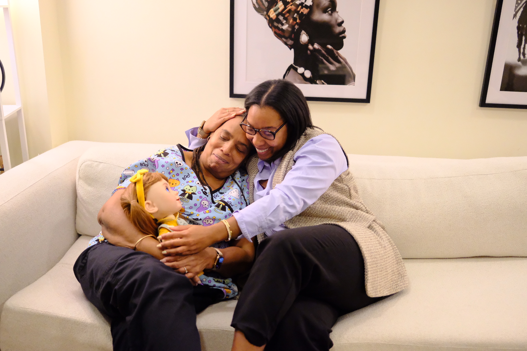 An older woman hugging her daughter while holding Joy