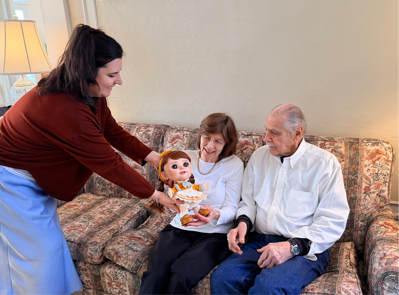 Joy being introduced to an older couple on their sofa