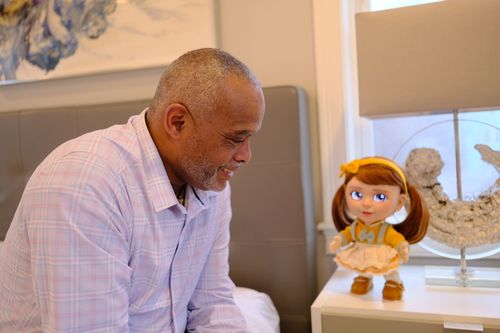 An older man chatting with Joy at his bedside