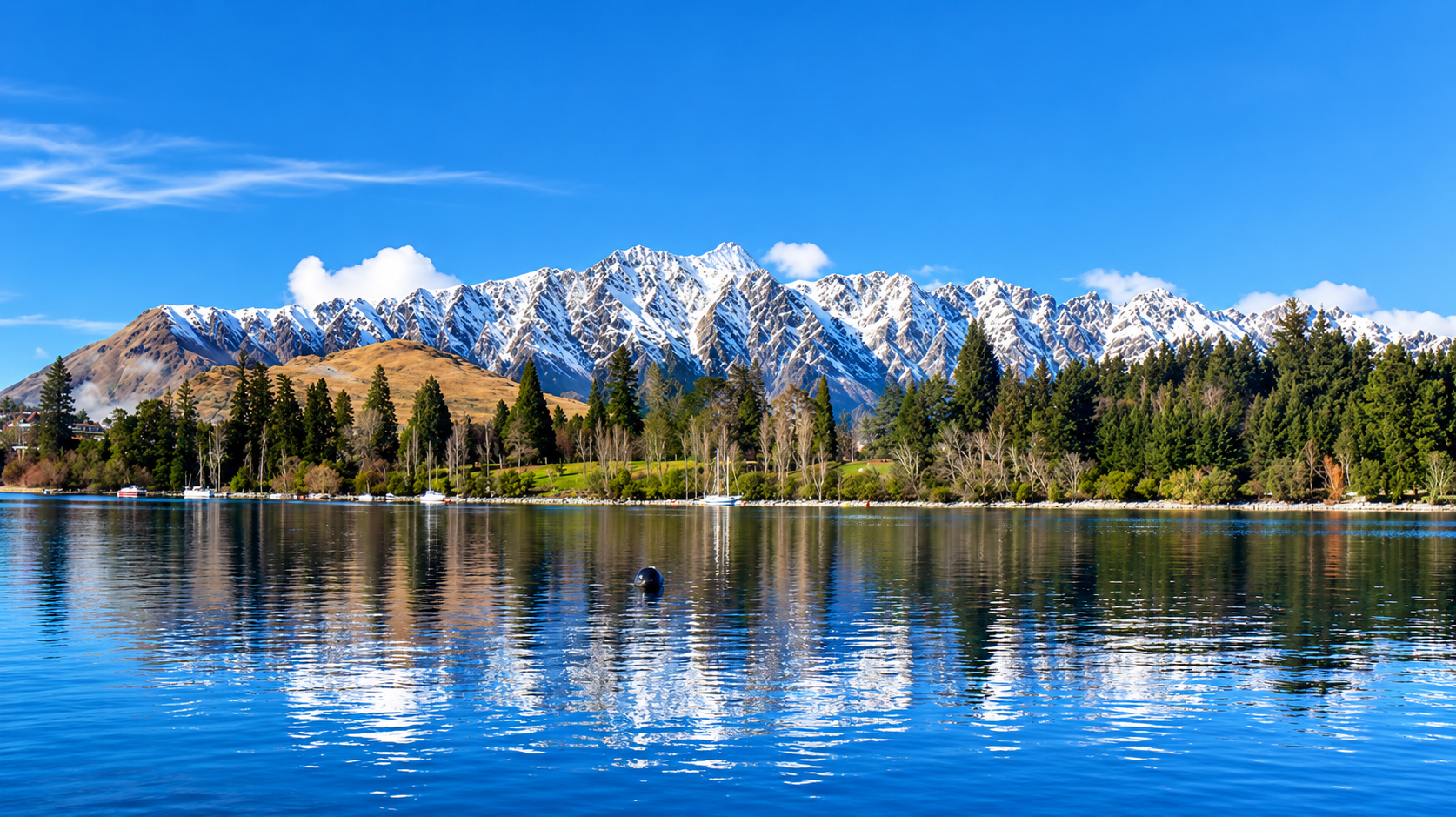 Snow-capped peaks reflected in an alpine lake near Queenstown