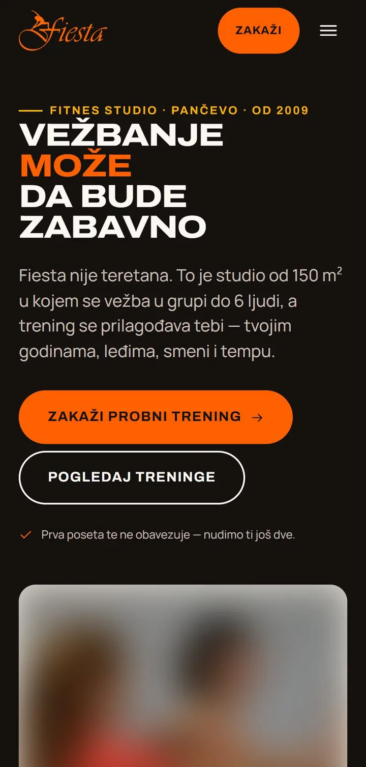 Fiesta Fitnes home page on a phone, studio photo blurred