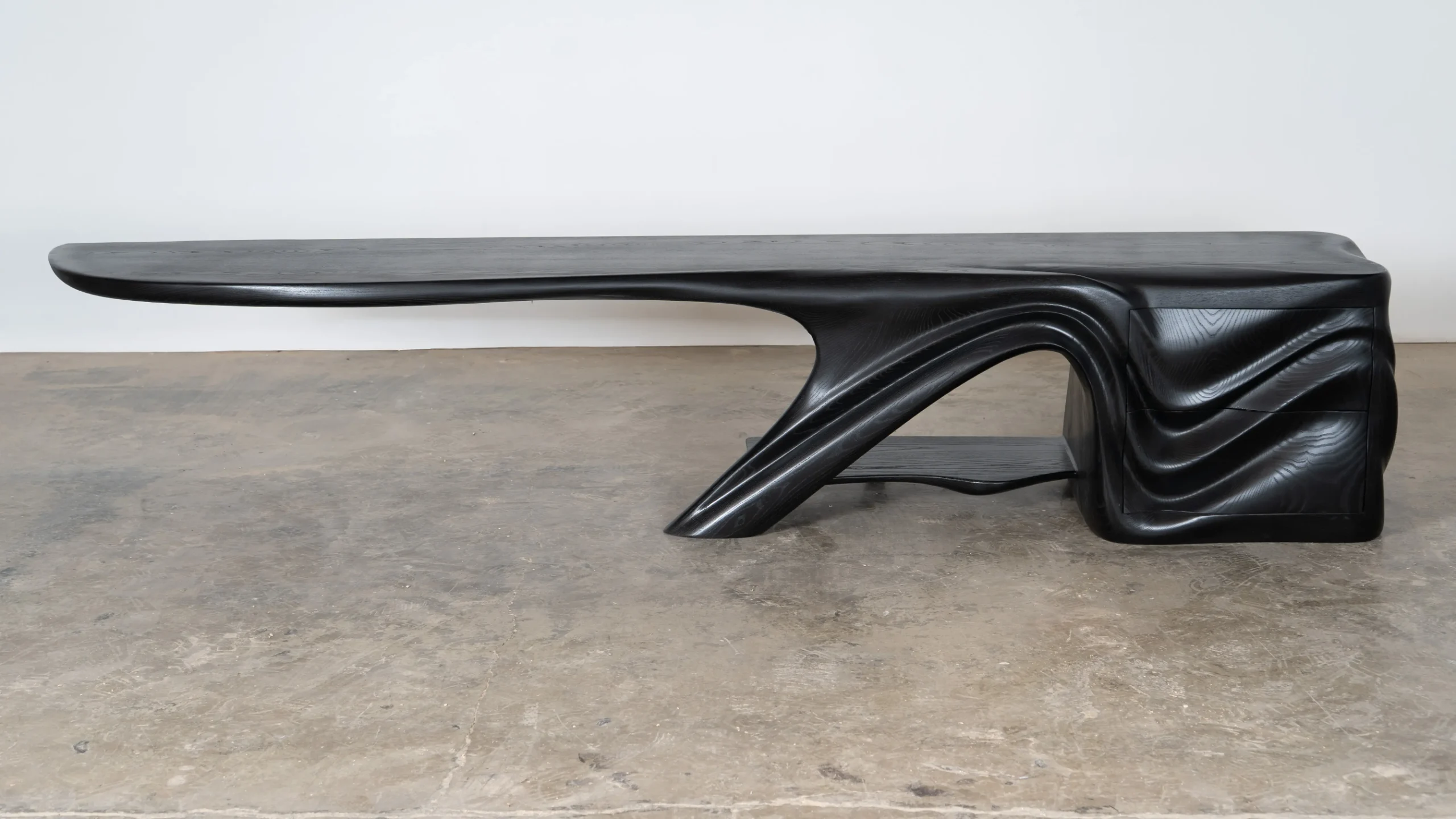 Sculptural solid wood media console in black finish by Amorph Studio