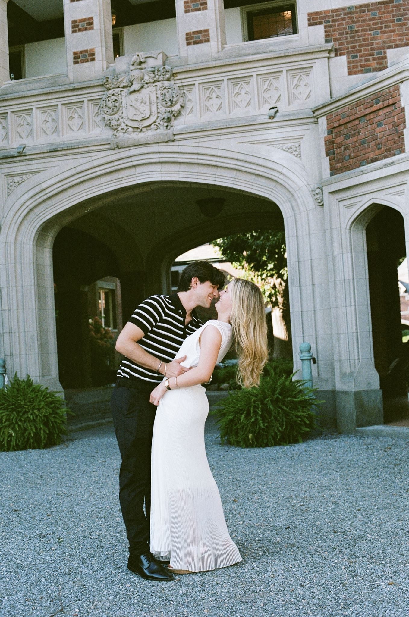 Caitlin and Greg kiss beneath the archway