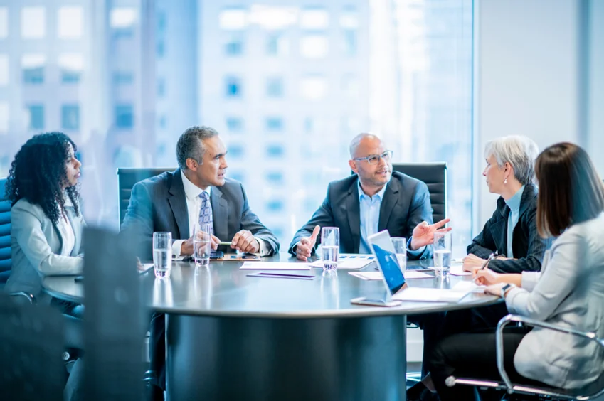 A board in discussion around a boardroom table