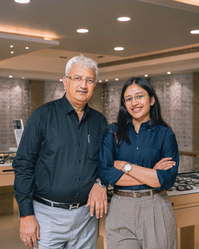 The Pearl Optics owners, father and daughter, standing together in the Jayanagar store