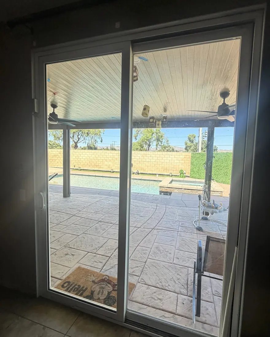 Sliding glass patio door with new warranty glass opening onto a covered patio and pool, Wildomar, CA