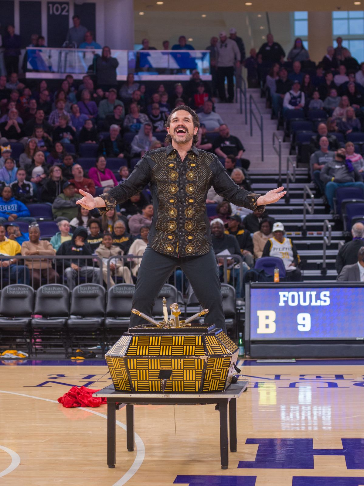 JP Wilson performing a sword box illusion at a High Point college basketball halftime show