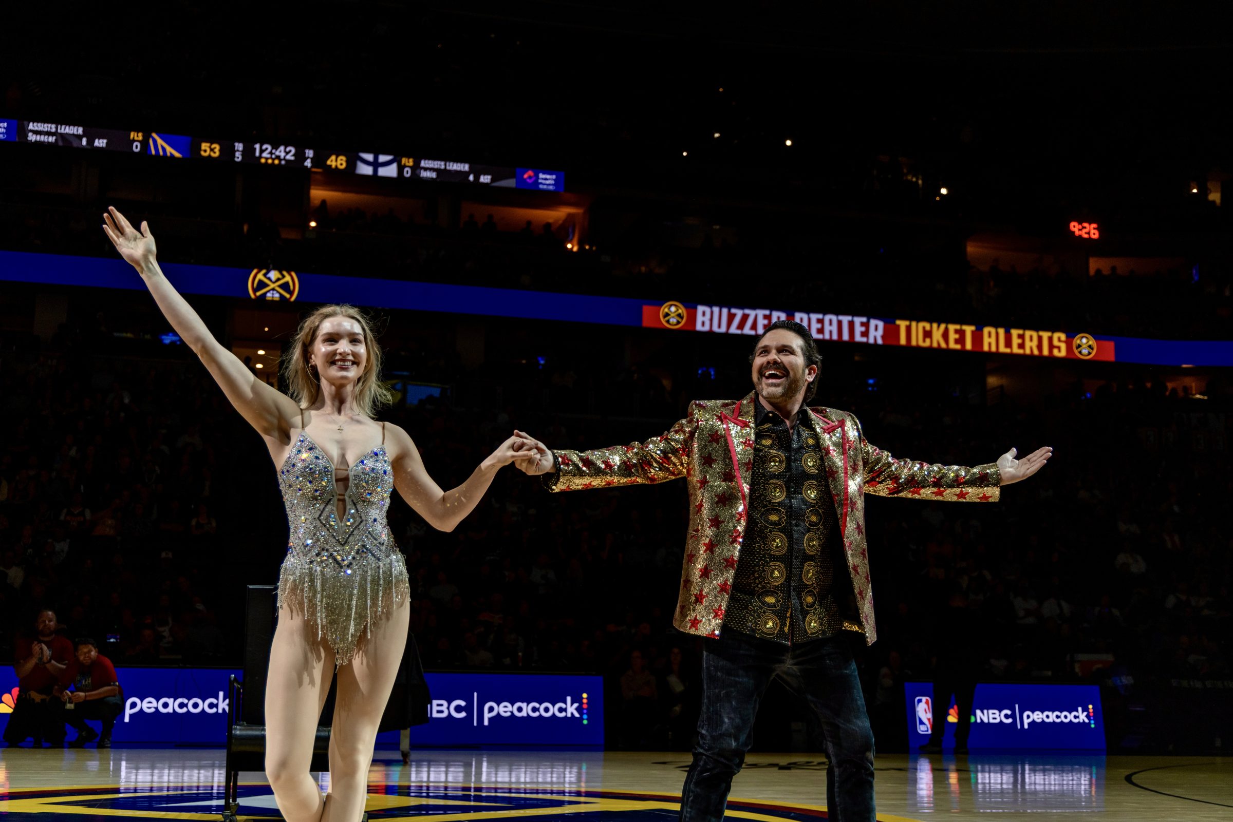 Magician JP Wilson and assistant performing a halftime illusion at a Denver Nuggets game