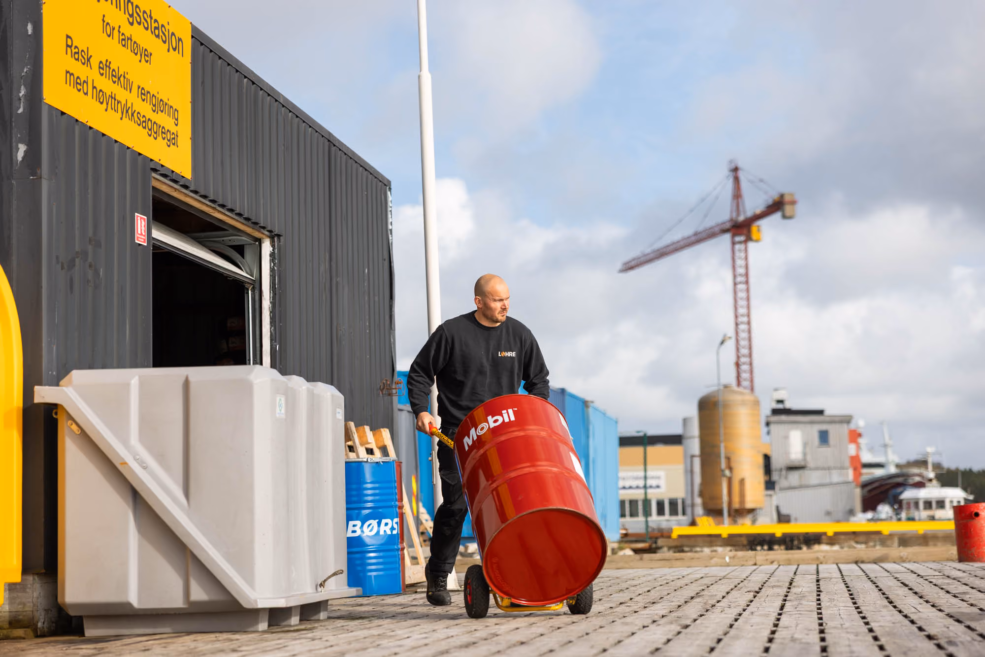 Ansatt triller et oljefat fra Mobil over kaia