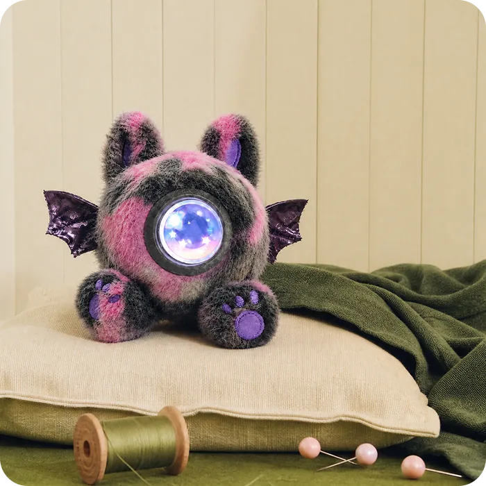 A dark Mumuland companion on a green throw