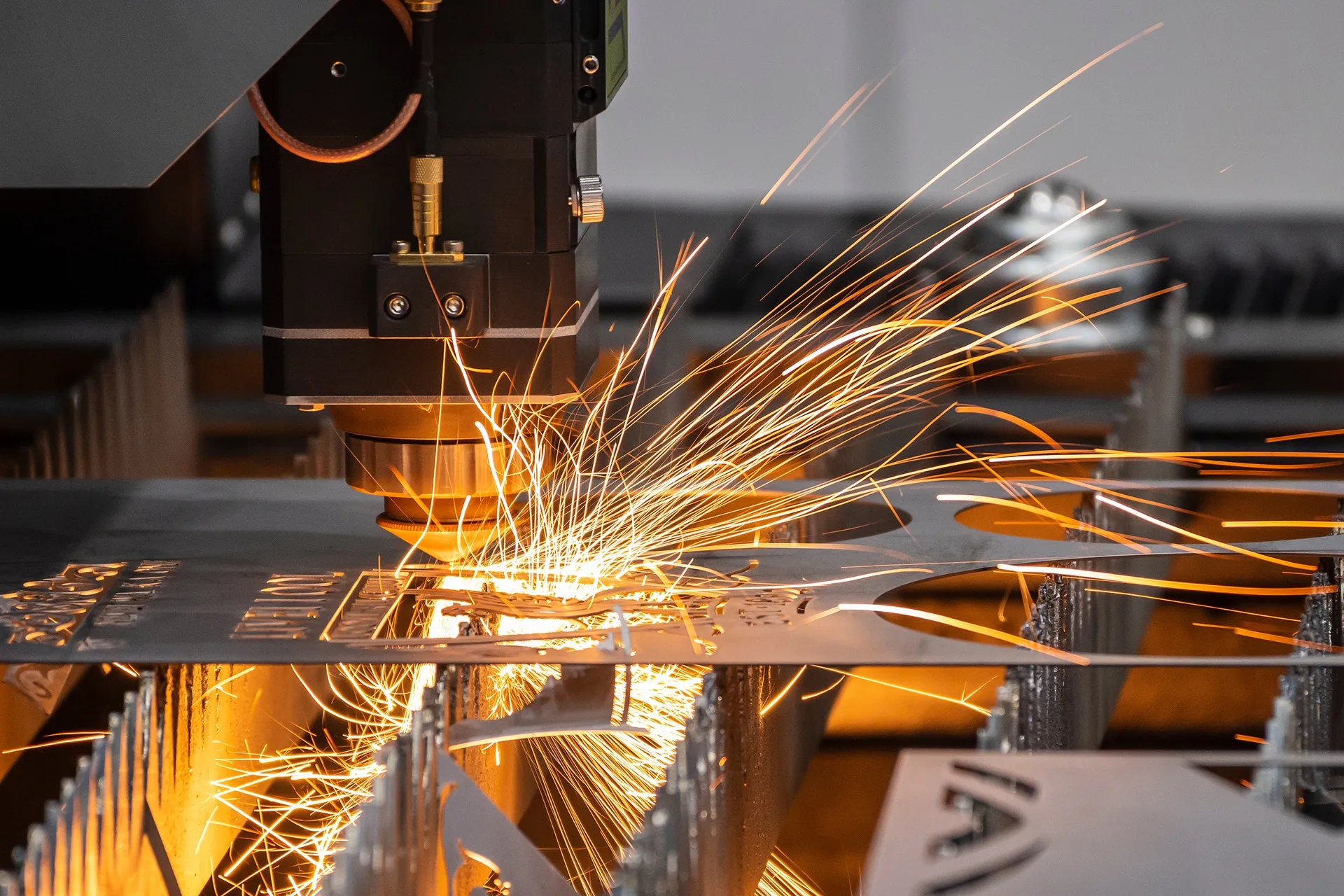 Laserleikkauskone leikkaa metallilevyä ja kipinät lentävät