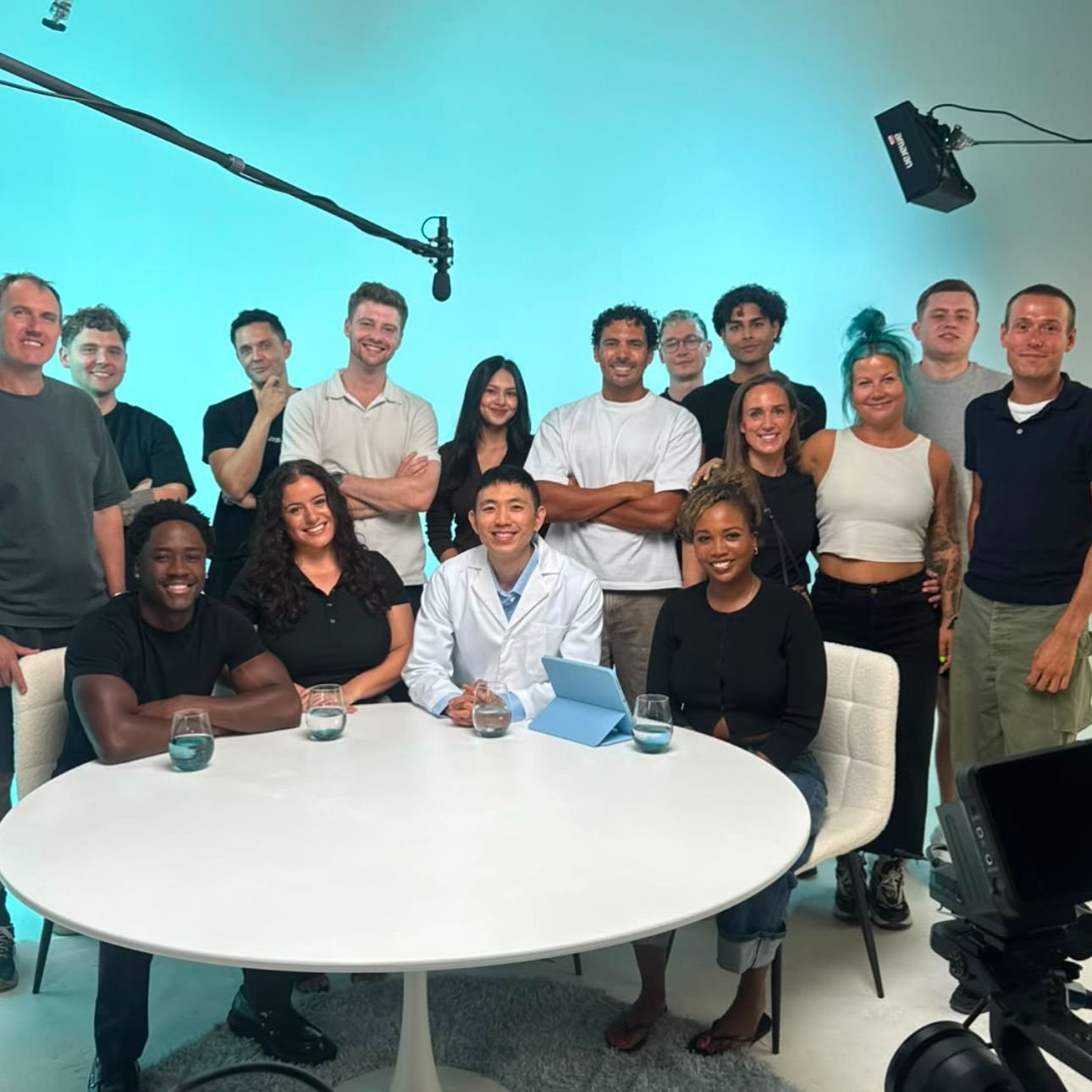 The Advertain cast and crew gathered around the set table in a studio