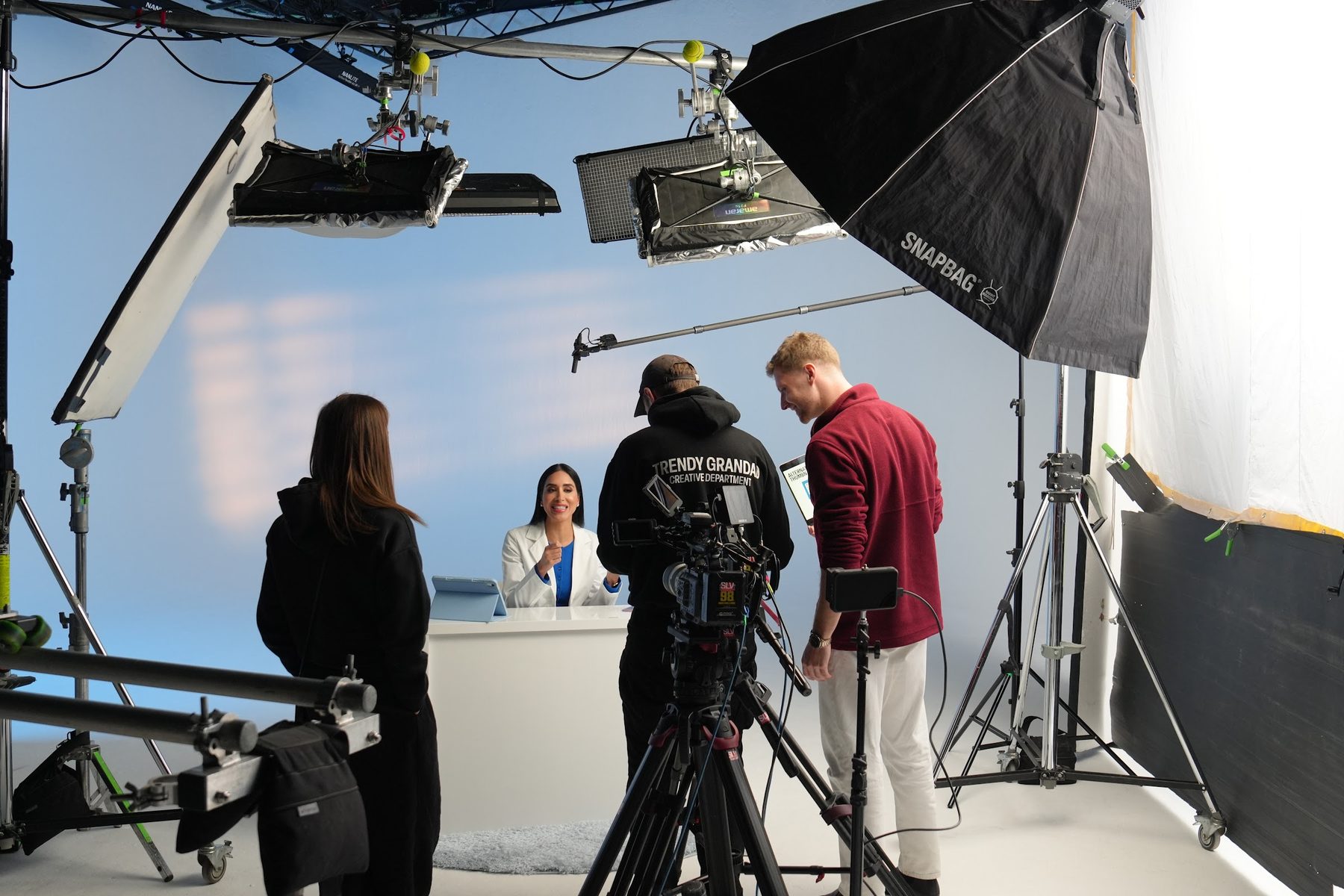 A film crew and presenter on a studio set during a brand shoot