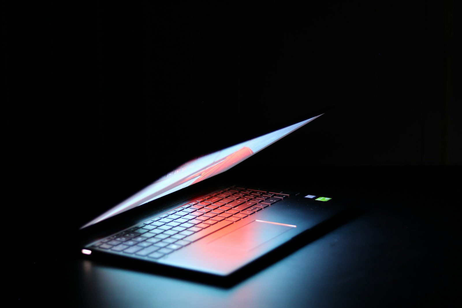 A laptop glowing in a dark room