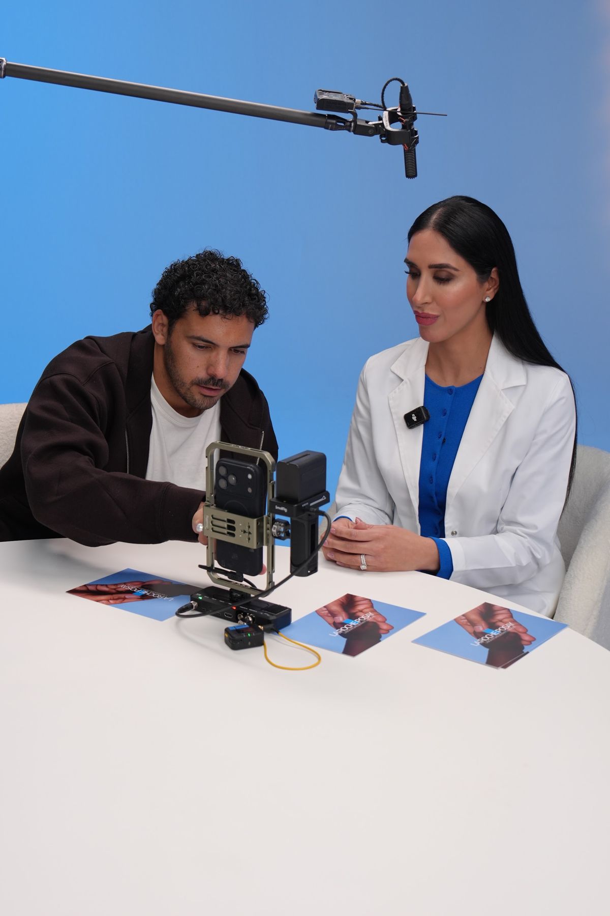 Dr Raj and a cast member recording at the table