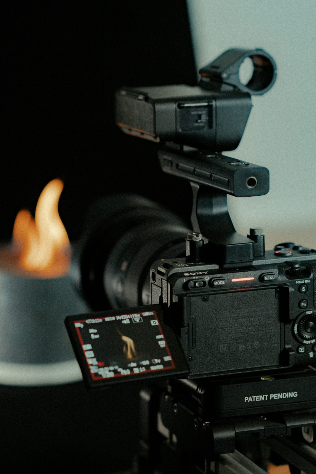 A rigged Sony cinema camera with its flip screen showing the shot