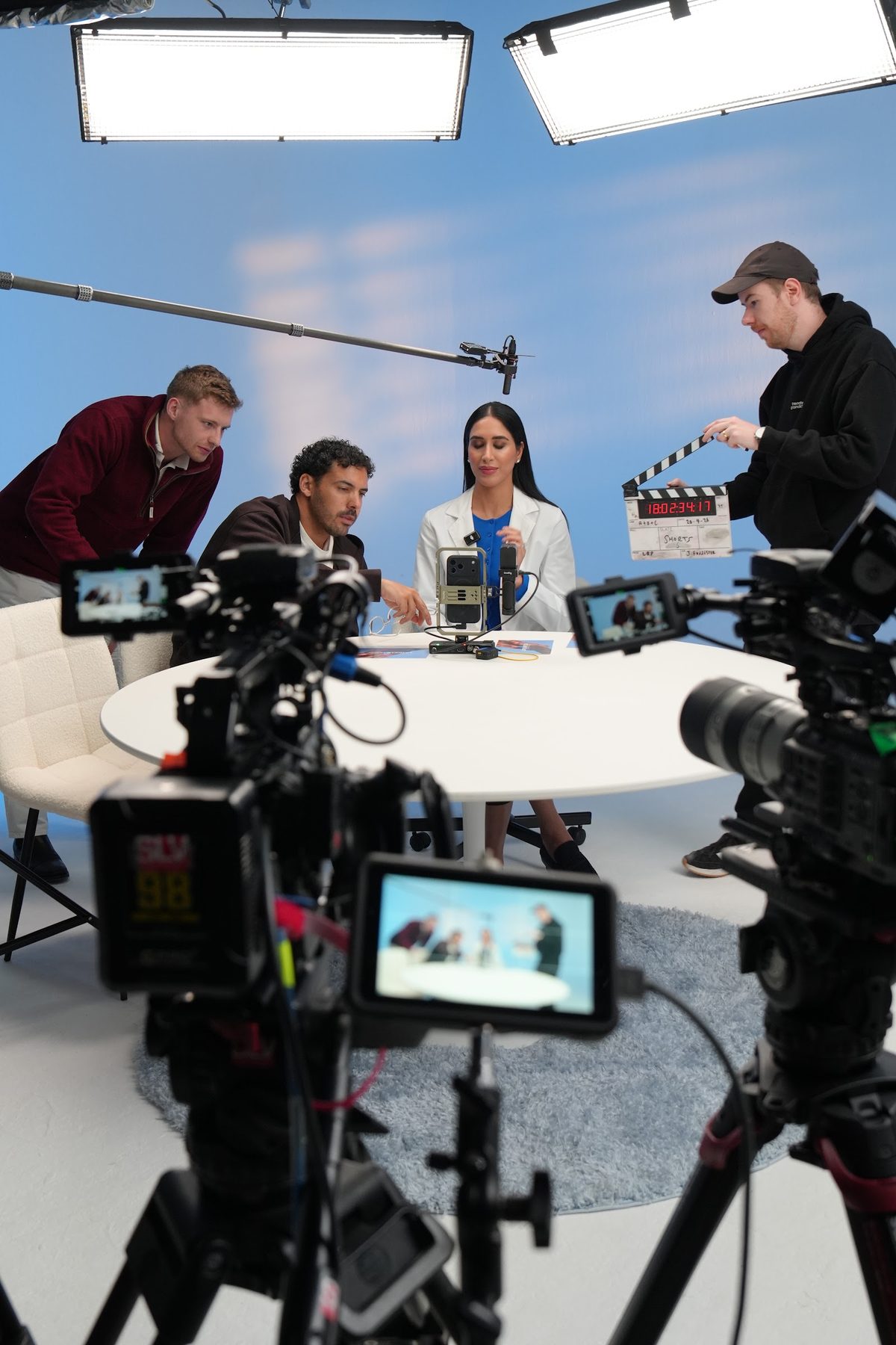 Behind the scenes on an Advertain studio shoot with cameras, lights and a presenter at a round table