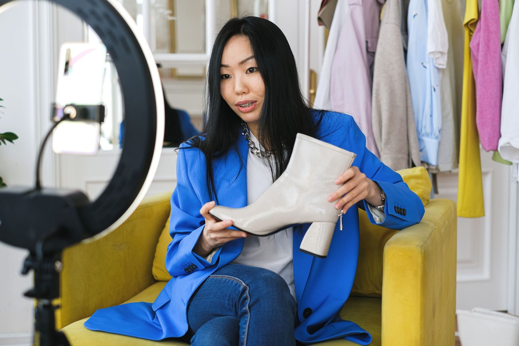 Creator holding a cream boot up to a phone on a ring light during a product video