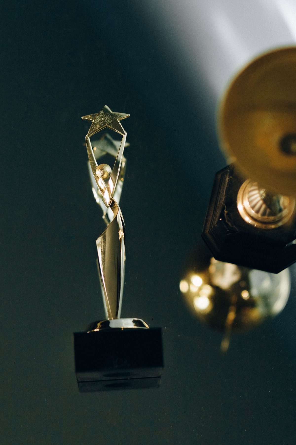 Golden star topped award trophy on a dark teal background