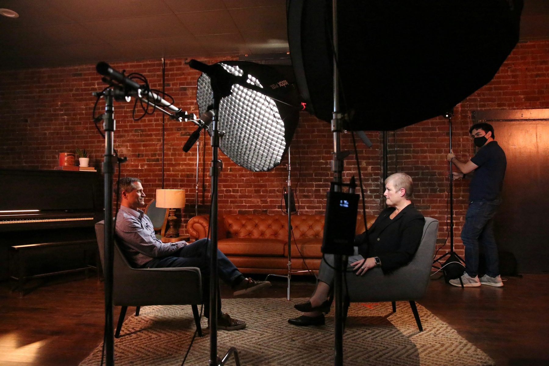 Film crew interviewing an executive in a warmly lit studio with softbox lights