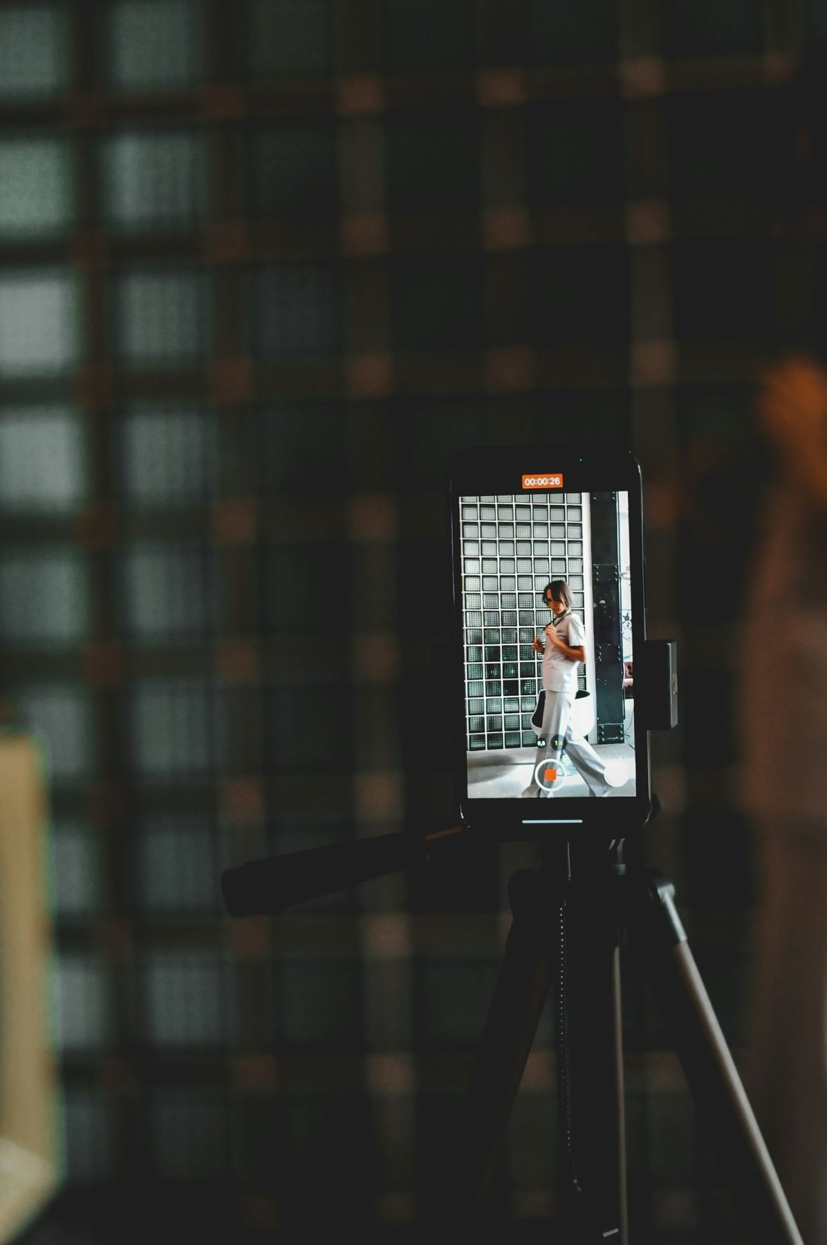 Phone mounted on a tripod recording vertical video in a dark room