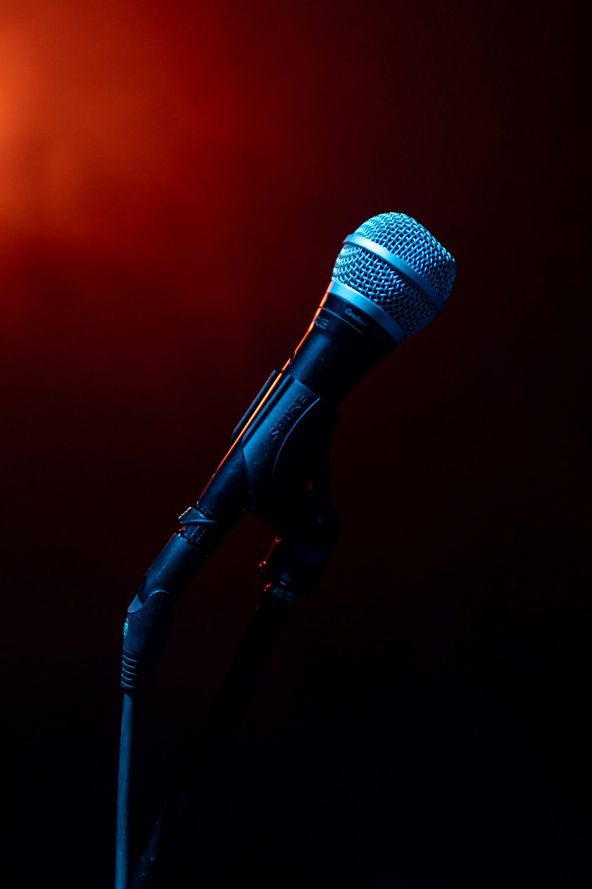 Microphone on a stand against a deep red background
