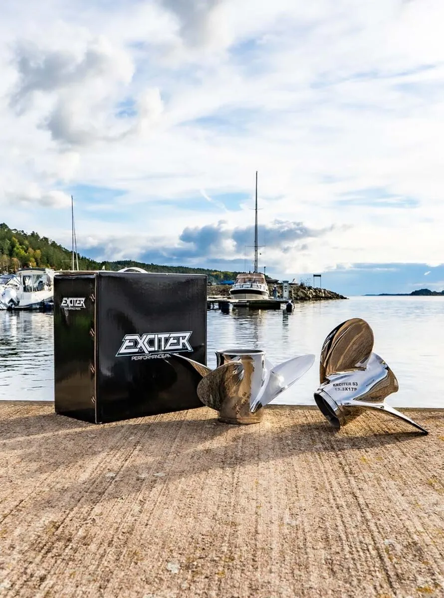 To Exciter stålpropeller og en Exciter-eske på en brygge ved sjøen