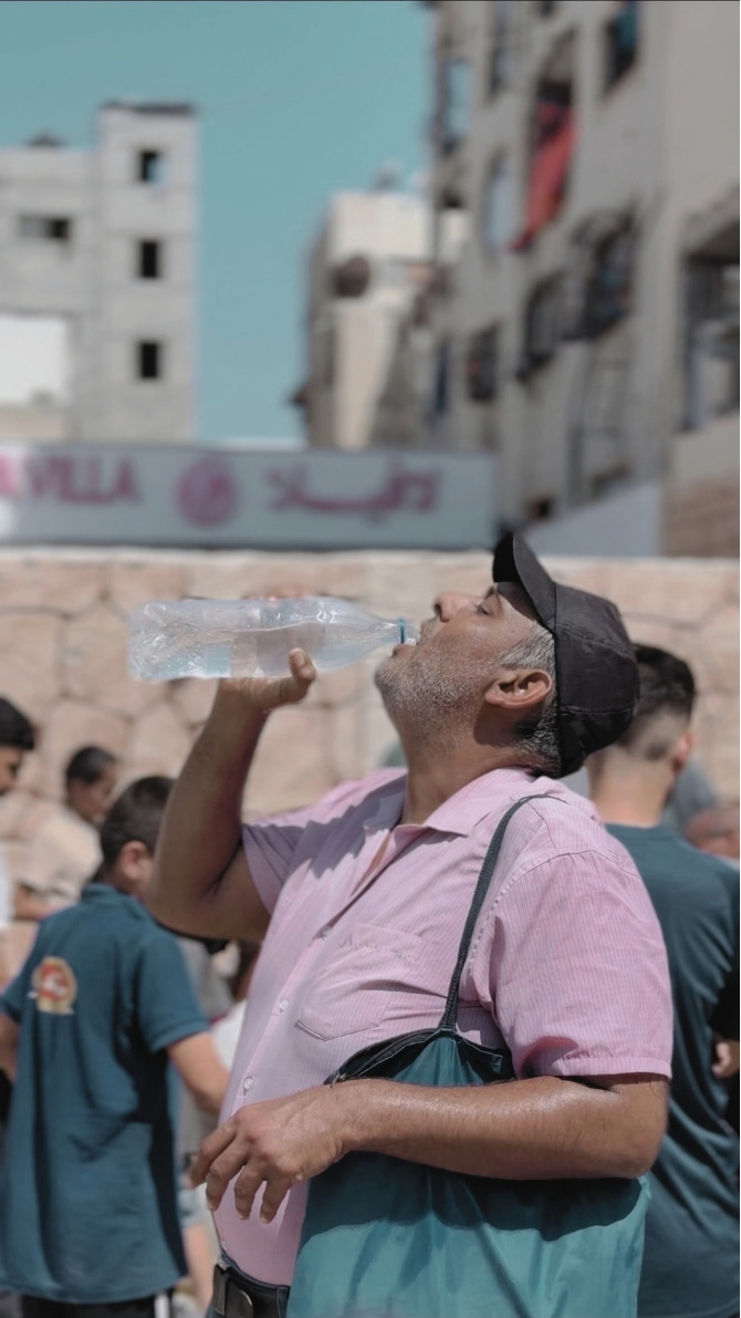 Ein Mann trinkt Wasser aus einer Flasche.