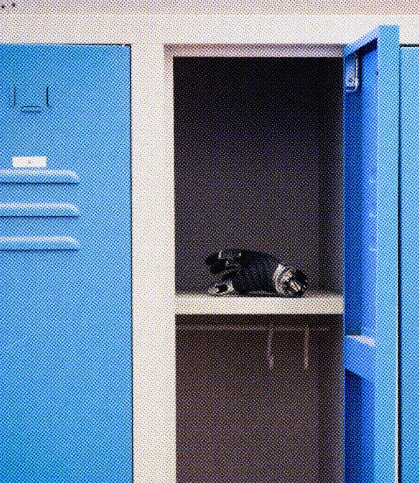 A robotic hand resting inside an open blue factory locker.