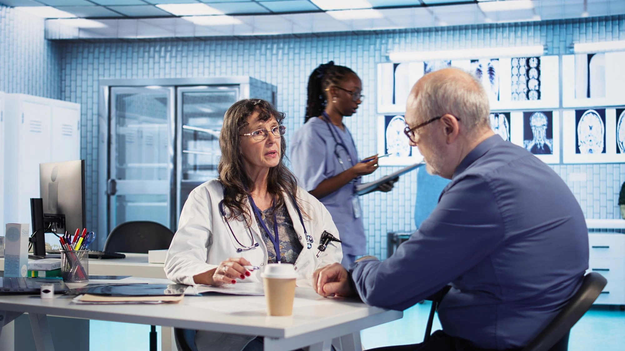 Doctor talking with a patient in a clinic while a nurse works in the background