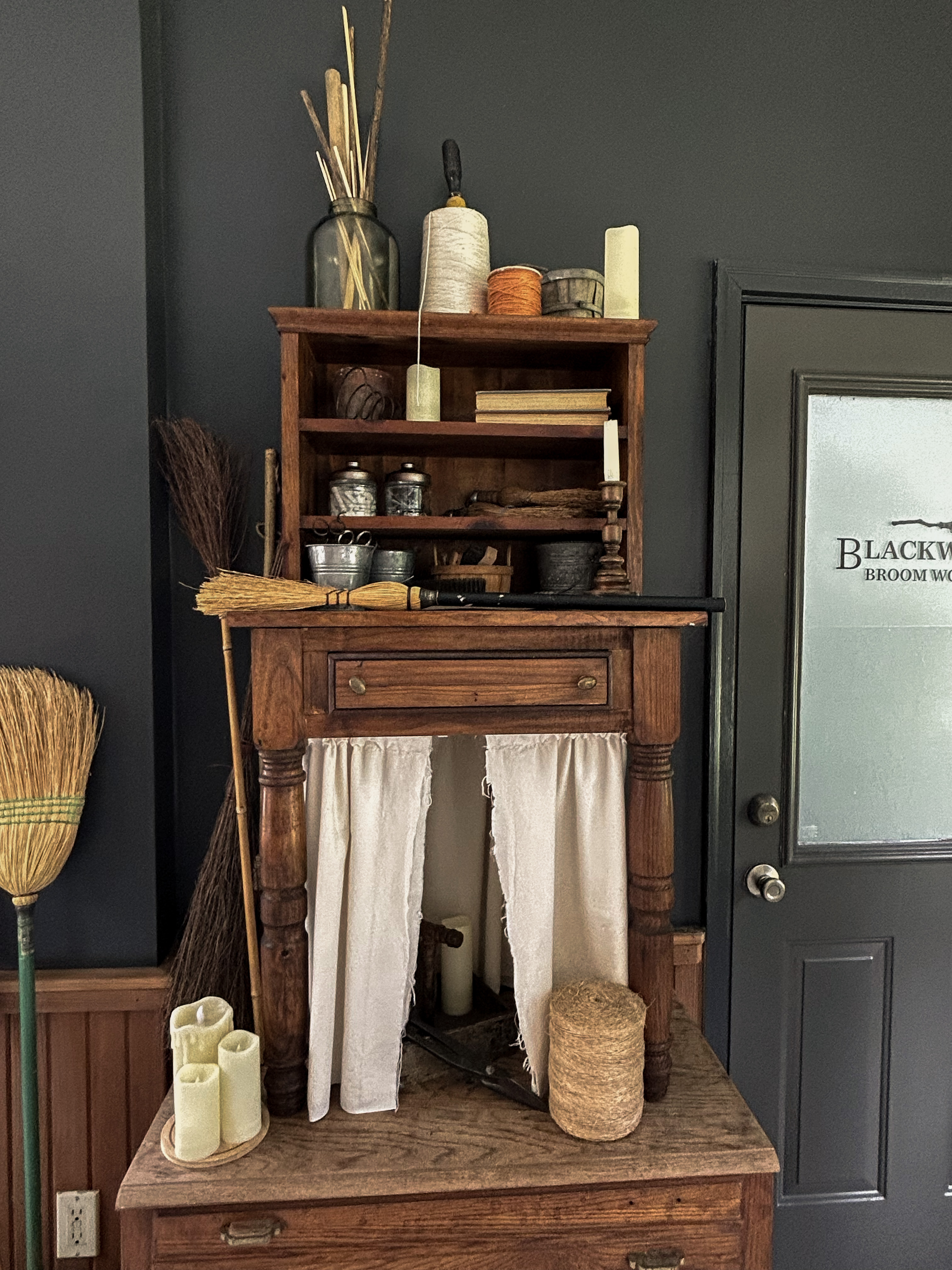 Wooden cabinet filled with broom-making supplies in the Blackwood workshop