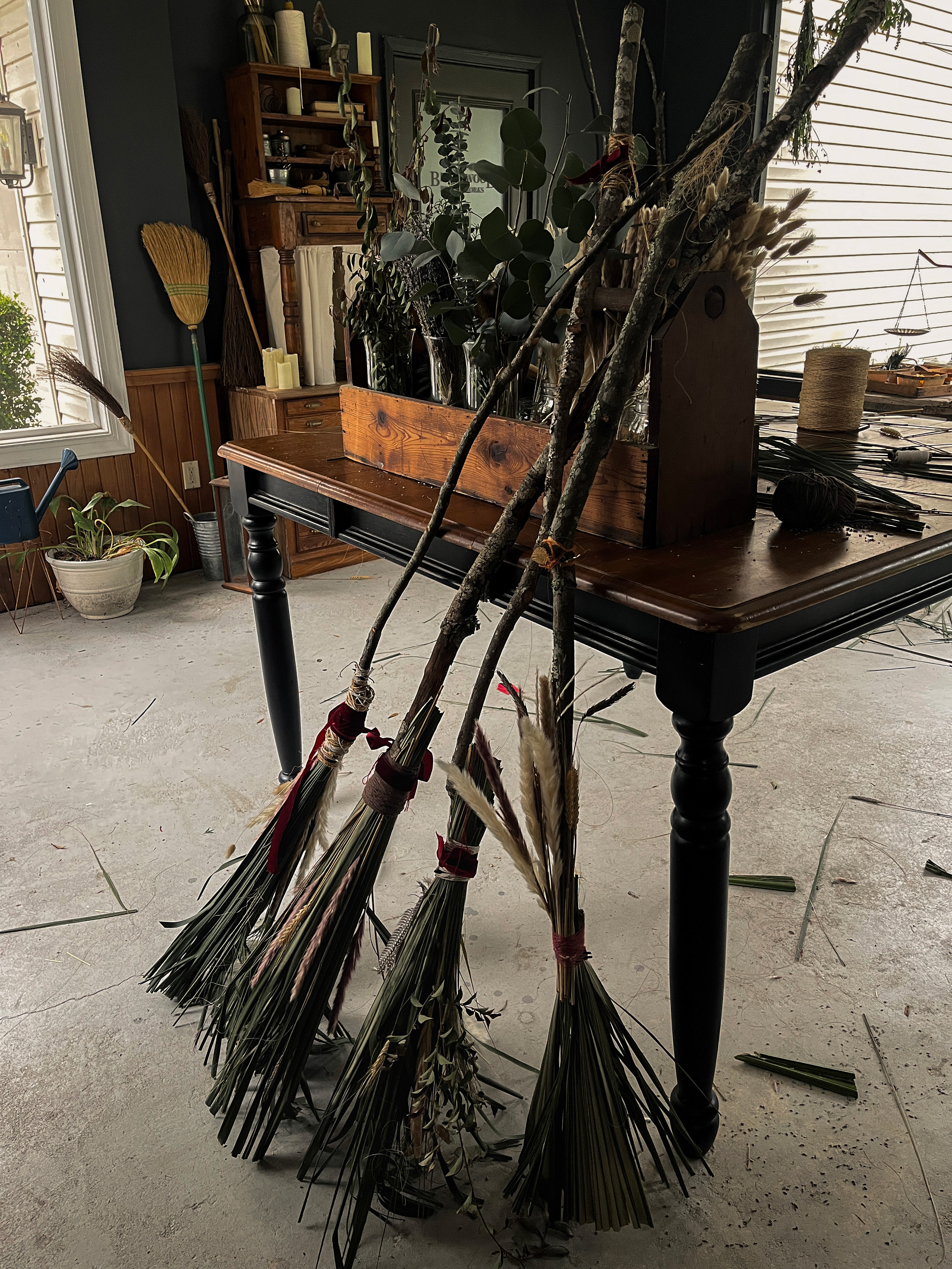 Finished handmade brooms leaning together after the workshop