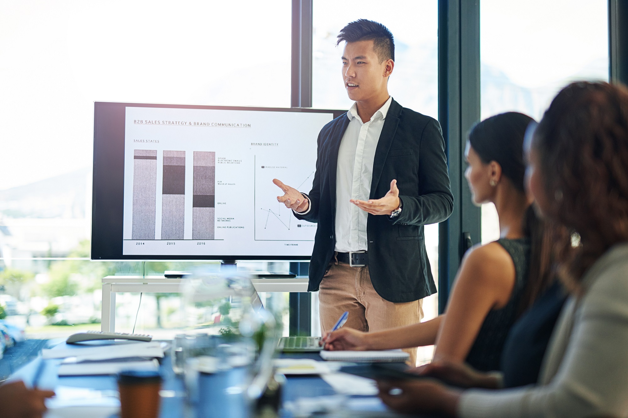 Presenter explaining a chart to colleagues in a meeting room