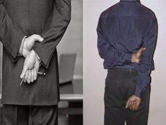 Man standing with his arms clasped behind his back
