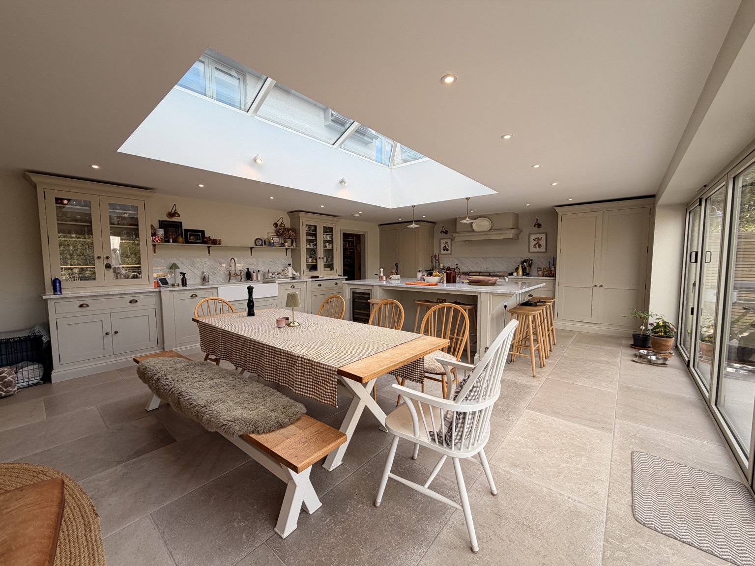 Kitchen and dining space with shaker cabinetry, an island and a glazed roof lantern