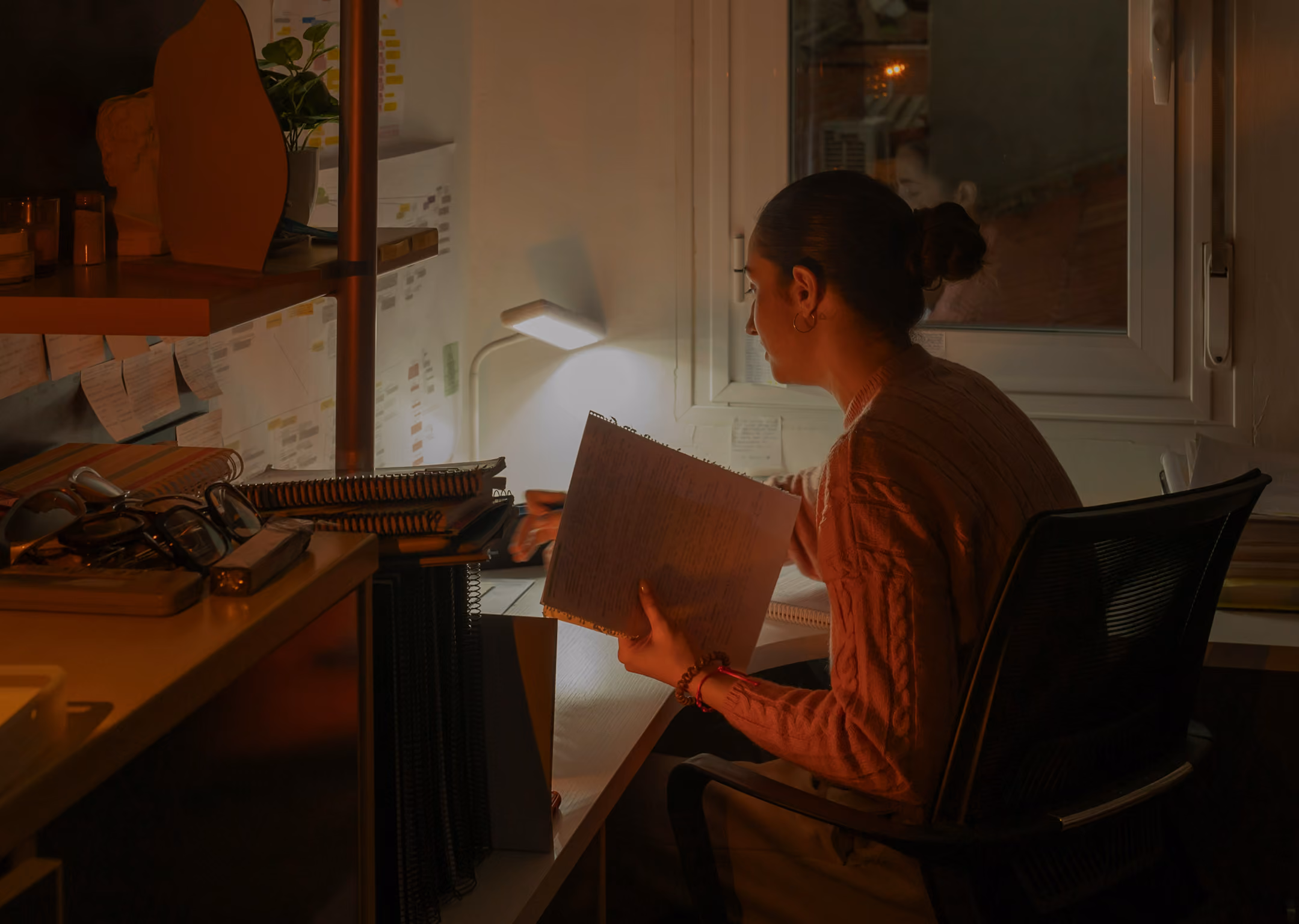 A business owner sits at her desk at night, working late