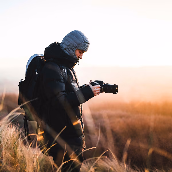 A photographer checks his camera