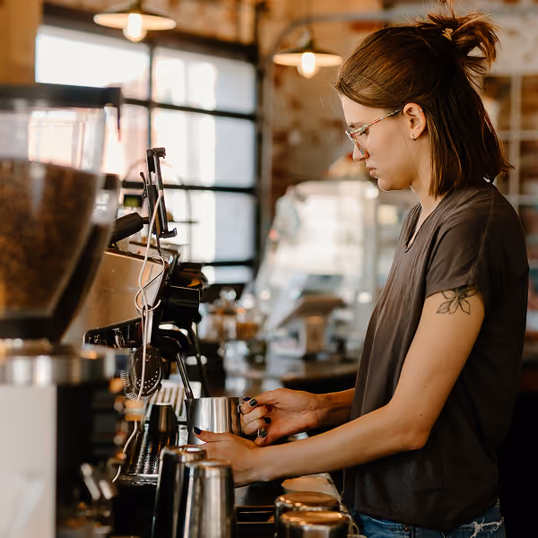 A barista makes coffee in a coffee shop