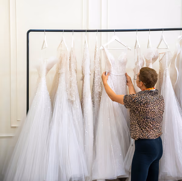 A woman arranges wedding dresses