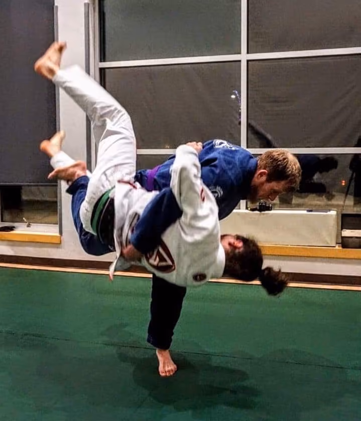 A person throws another while doing jiu jitsu