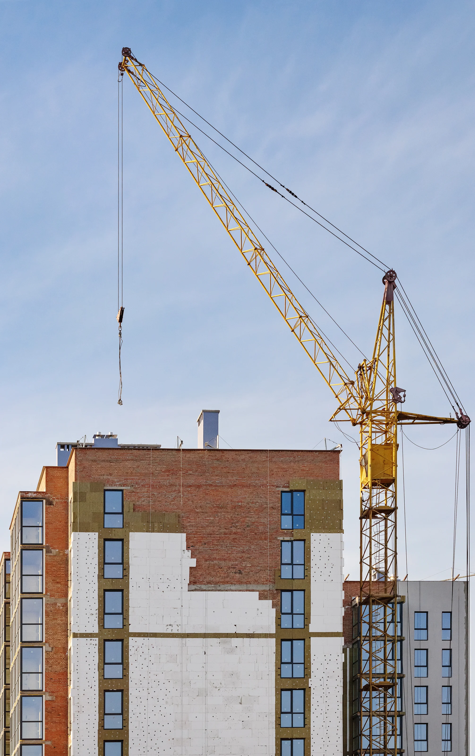 Façade de logements neufs en cours d'achèvement, avec une grue