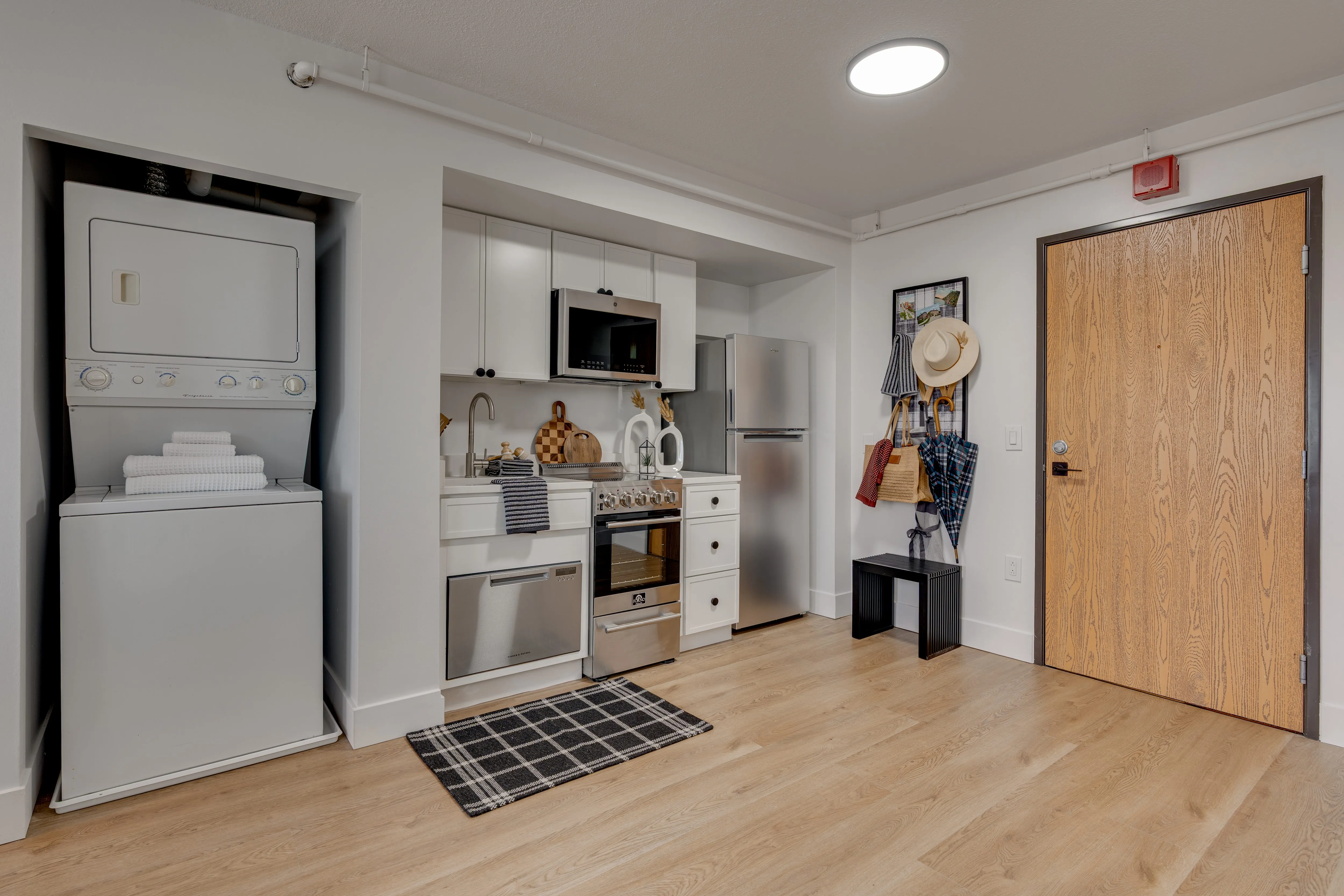 Buckner apartment kitchen with range, dishwasher, fridge and stacked in-unit washer and dryer