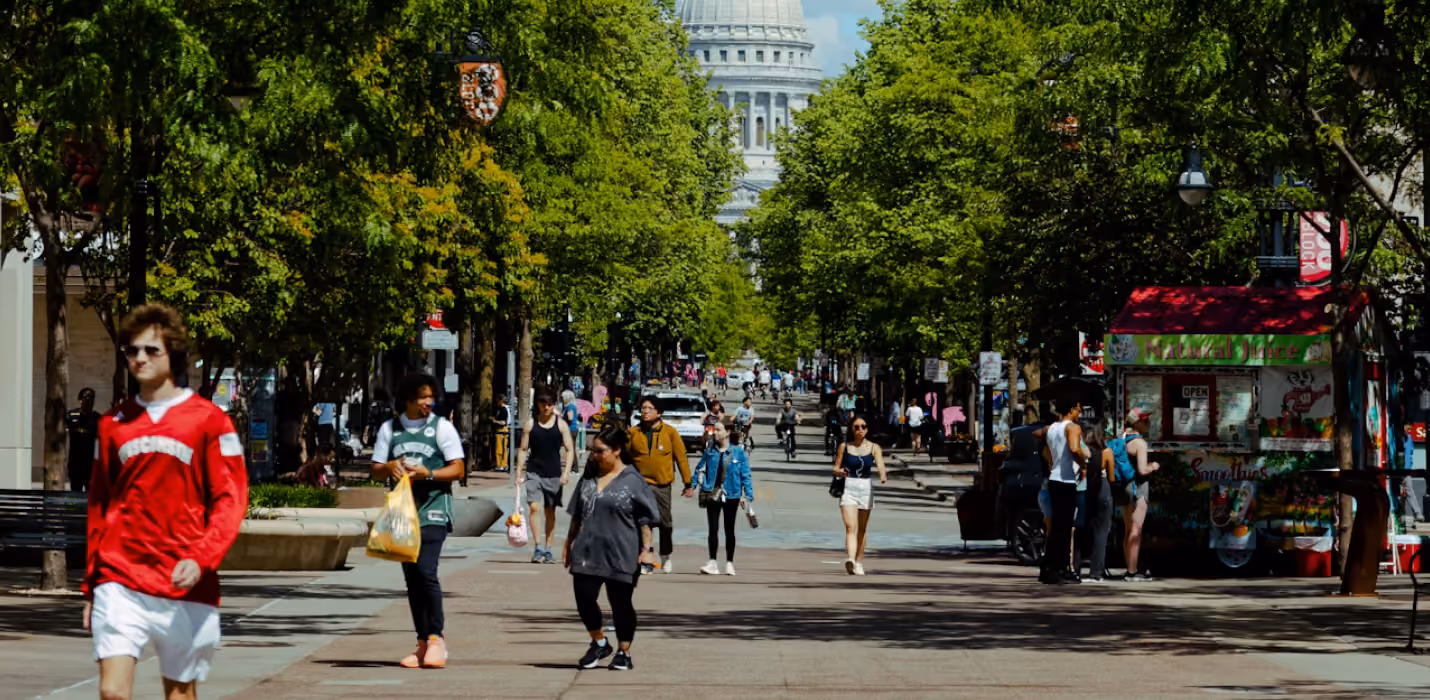 State Street in Madison with shoppers and the Wisconsin State Capitol dome at the end of the street