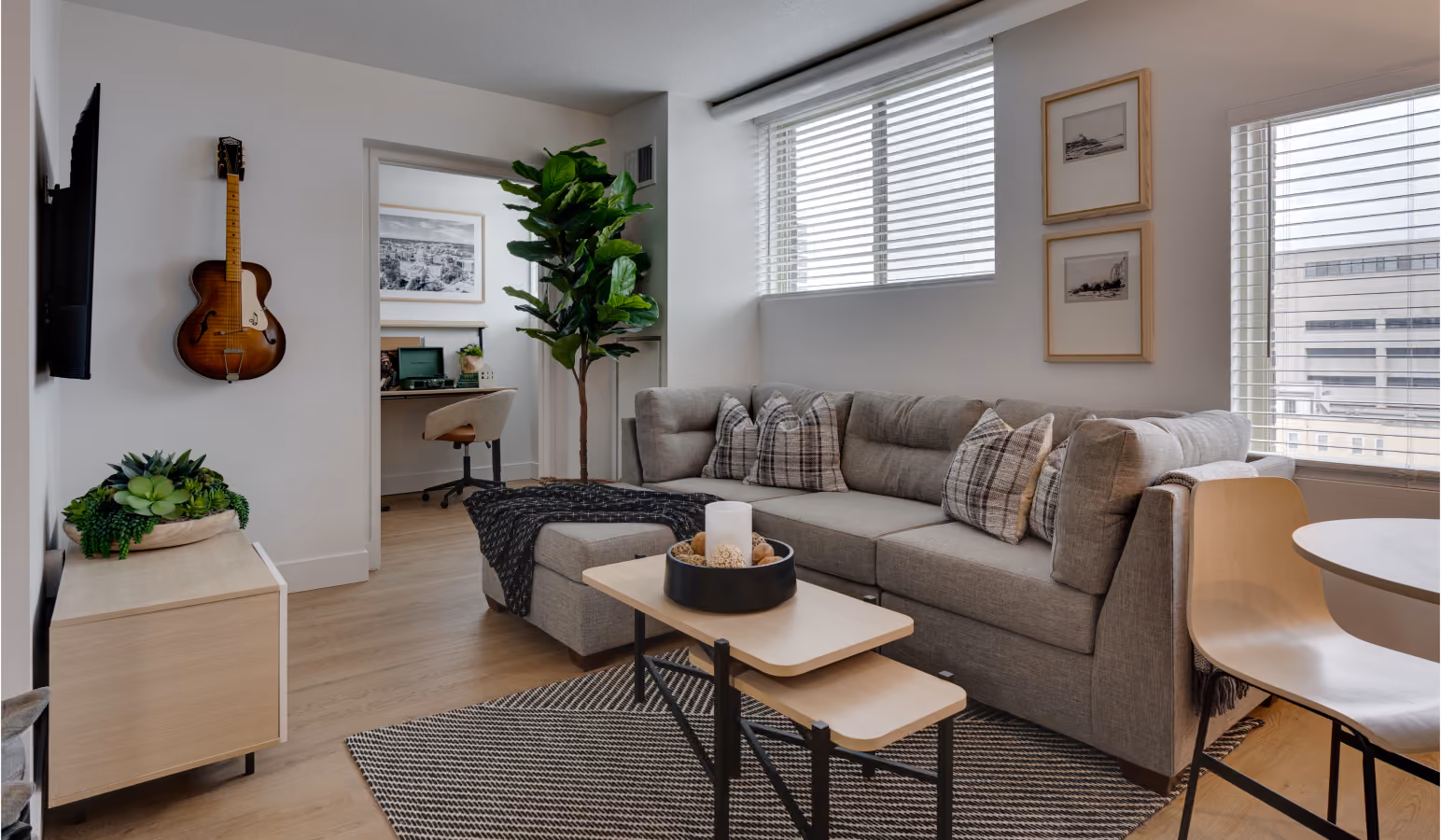 Buckner living room with a gray sectional, wall-mounted TV and a study nook