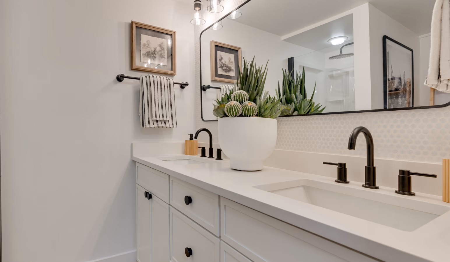 Buckner bathroom with a double-sink vanity, black fixtures and a large mirror