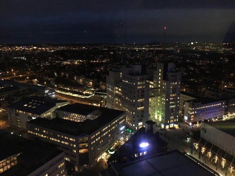 Stockholm at night seen from high above, lit apartment towers and streets stretching to the horizon
