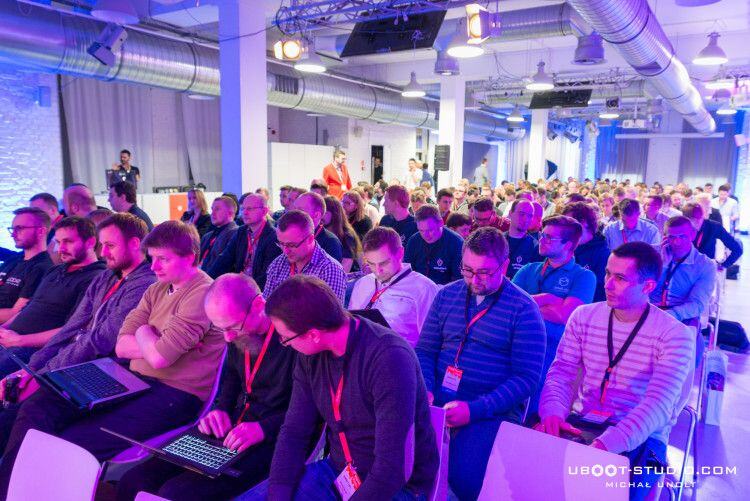 Packed audience with lanyards and laptops watching a talk at Meet Magento PL 2015 in Concordia Design, Poznań