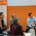 People seated and listening to a talk at the Meet Magento stand at CeBIT 2013
