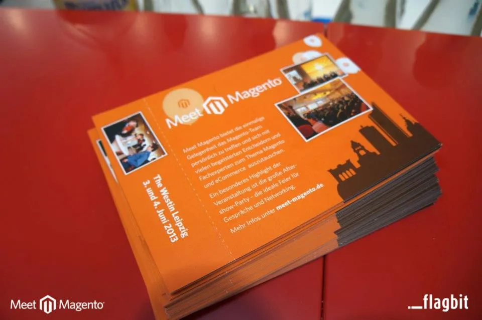 Stack of orange Meet Magento flyers for The Westin Leipzig, 3 and 4 June 2013, on a red table at CeBIT
